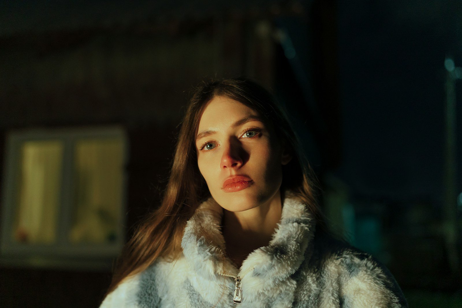 A woman in a fur coat standing in front of a building